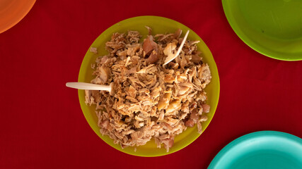 Generous portion of carnitas pork meat on a plate mixed with roasted peppers for a full flavor meal.