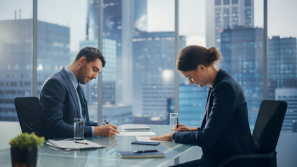 Female and Male Business Partners Sign Successful Deal Documents in Meeting Room Office. Corporate CEO and Investment Manager Agreed on a Lucrative Financial Opportunity.