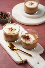 Italian chocolate and coffee mousse dessert semifreddo - half-frozen ice cream with whipped cream and cocoa powder in small glasses on purple surface