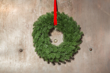 Decorative Advent wreath or crown bonded with fir branches and fixed at a house entrance door with...