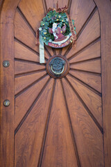 Decorative Advent wreath or crown with Santa Claus fixed at a wooden vintage house entrance door 
