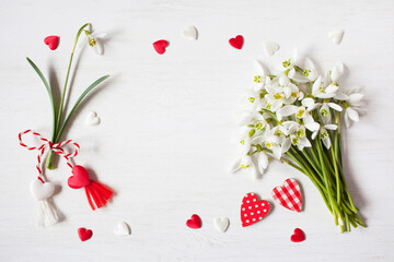 Obraz na płótnie Canvas A bouquet of snowdrops flowers, red and white hearts on a white wooden background, space for text.