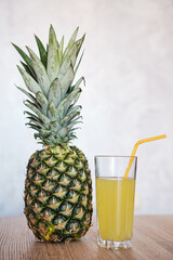 Freshly made pineapple juice on a wooden table. Place for text