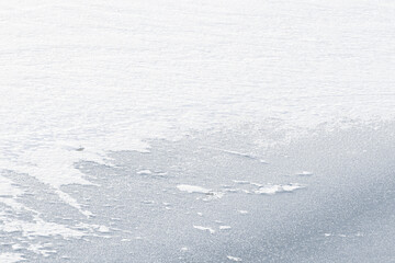 winter white texture drone shot of ice and snow on a frozen lake
