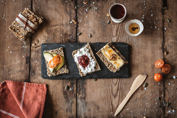  deliciosas tostadas de pan sueco de semillas en mesa de madera antigua, servidas en pizarra negra. desayuno saludable. Knäckebröd 