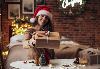 Woman packing Christmas gifts boxes. Unprepared gifts on a white table with decor elements and items Christmas or New Year DIY packaging concept.