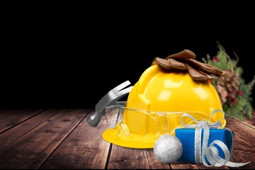 Construction hard hat and plumbing items with Christmas and New Year decoration over holiday...
