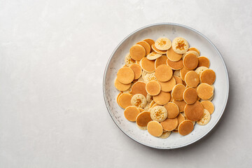 Pancake cereal or mini pancakes in plate on concrete background - obrazy, fototapety, plakaty