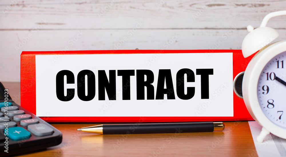 Poster red folder for papers with the text contract, white alarm clock, calculator and pen on the desktop. 