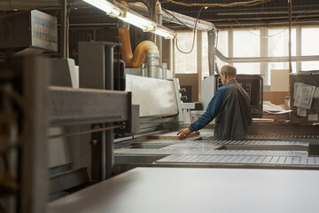 Fototapeta na wymiar Competent craftsman working in modern furniture manufacture