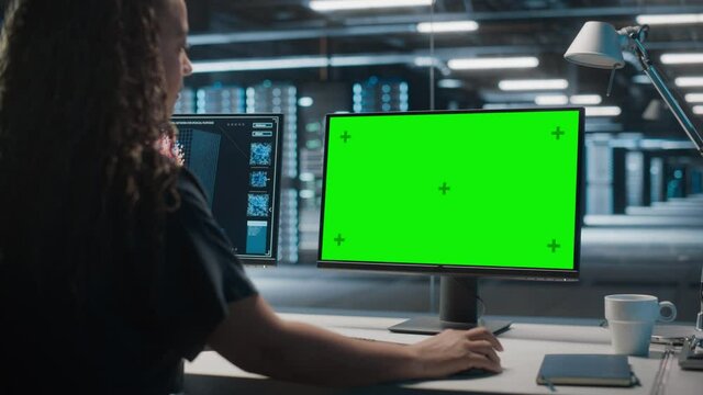 High-Tech Data Center Server: Black Female IT Specialist Working on Green Screen Chroma Key Computer. Monitoring Web Services, Cloud Computing, Analytics Facility, Maintenance of Cyber Security