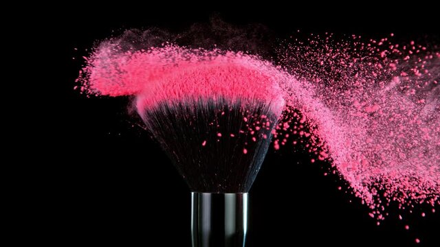 Super Slow Motion Shot of Pink Powder and Makeup Brushes Touch Each Other at 1000 fps.