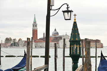 Pier with gondolas and green lamp in Venice