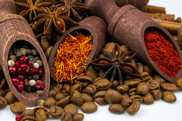 Spices in wooden spoons, coffee on a white background.