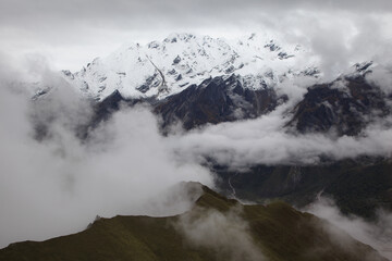 views of snow-capped mountain peaks in the clouds in lantang