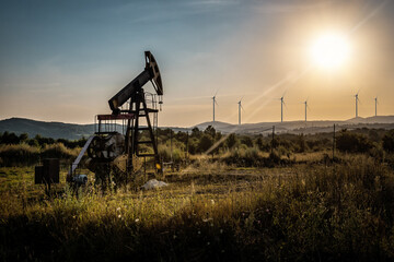 Fototapeta na wymiar industrial oil pump and windmills