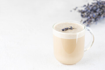 Raf coffee with coconut milk and lavender in a glass mug on the table. Horizontal orientation, copy...