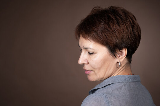 Close-up Of Mature Woman With Short Brown Hair Posing At Camera Isolated On Grey Background