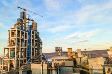 Aerial view of cement plant with high factory structure and tower crane at industrial production...