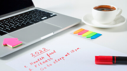 cup of coffee and laptop and to do list 2022 on white background