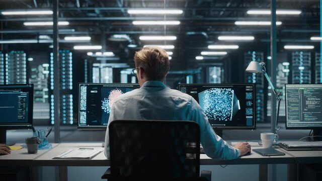 High-Tech Data Center Server Control: IT Specialist Administrator Working on Computer, Screen Advanced Showing Big Data AI Analysis. Web Services, Cloud Computing, Analytics Facility, Cyber Security