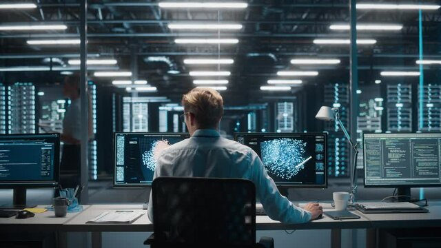 High-Tech Data Center Server Control: IT Specialist Administrator Working on Computer, Screen Showing Advancing Big Data AI Analysis. Web Services, Cloud Computing, Analytics Facility, Cyber Security