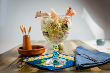 Front view of a refreshing Shrimp cocktail with lettuce and pineapple served in a glass and covered with seafood sauce.