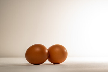 Two chicken, brown eggs, on a light background. Two textured chicken eggs, with a textured surface.