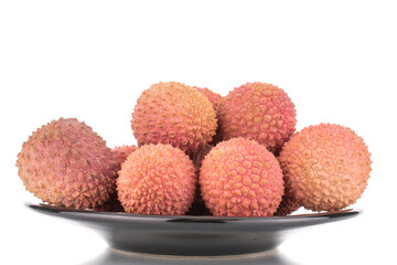 Several juicy sweet litchi fruit on a ceramic plate, close-up, isolated on white.