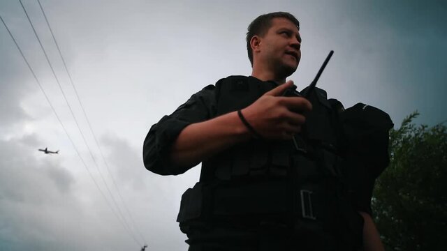 Bottom view of A SWAT commander in a black uniform.