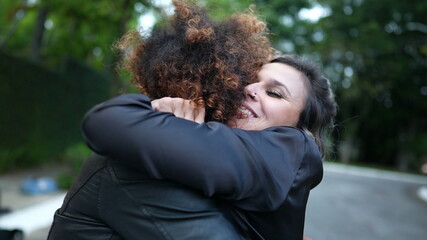 Two young women embrace. diverse friendship genuine hug