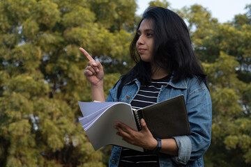 Fototapeta premium College student with books showing something