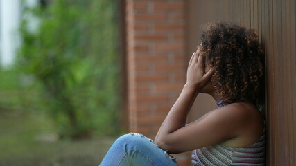 Person covering face with hands in shame. woman leaning on wall