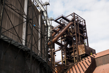 Metallurgical rusty tower with pipes.
