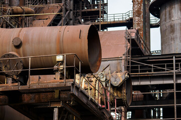 Fototapeta na wymiar Metallurgical rusty tower with pipes.