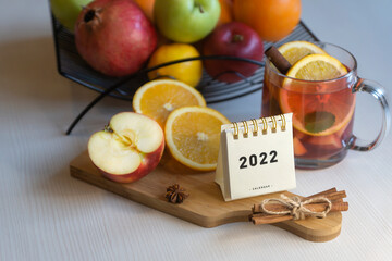 Fruit tea, various fruits in a basket on the table. Calendar 2022, winter mood and spruce branches.