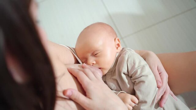 breastfeeding. mother feeds baby with breast milk. child falls asleep. 