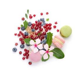 A scattering of juicy berries, flowers and macarons.