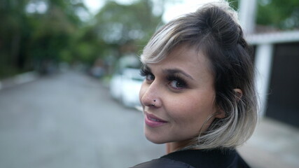 Happy woman turning head toward camera smiling