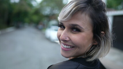 Happy woman turning head toward camera smiling