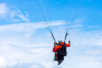 paragliding against the backdrop of cumulus clouds and blue sky