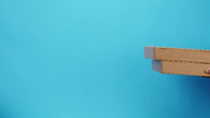 Square cardboard boxes on blue background. Preparing take away meals. Online contactless food shopping. Food delivery service. Courier in protective gloves giving order, delivering to customer. 