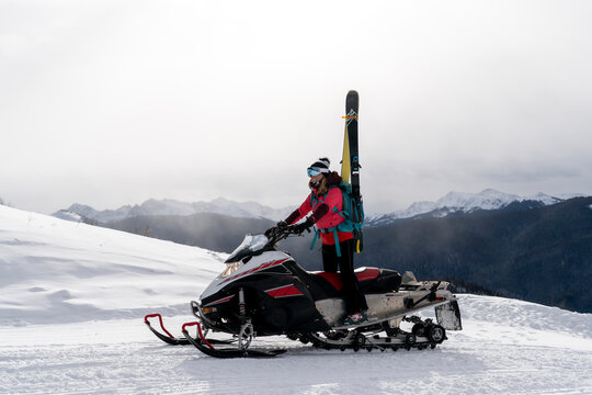 Adventurous woman riding snowmobile in winter