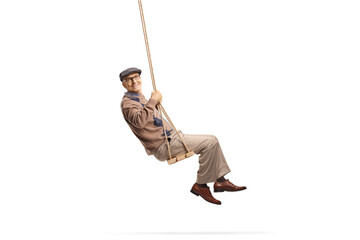 Cheerful elderly man swinging on a wooden swing - obrazy, fototapety, plakaty