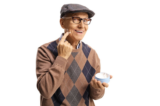 Elderly man applying a face cream and smiling