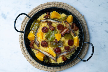 Bread crumbs with chorizo, green pepper, orange, bacon and fried anchovies. Traditional Spanish tapa.
