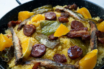 Bread crumbs with chorizo, green pepper, orange, bacon and fried anchovies. Traditional Spanish tapa.