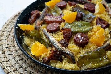 Bread crumbs with chorizo, green pepper, orange, bacon and fried anchovies. Traditional Spanish tapa.