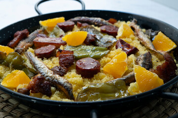 Bread crumbs with chorizo, green pepper, orange, bacon and fried anchovies. Traditional Spanish tapa.