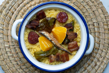 Bread crumbs with chorizo, green pepper, orange, bacon and fried anchovies. Traditional Spanish tapa.